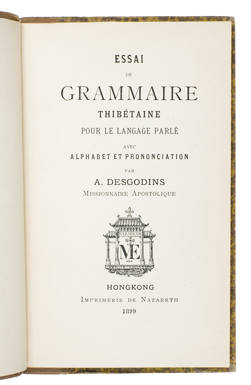 DESGODINS, Auguste. - Essai de grammaire Thibtaine pour le langage parl, avec alphabet et prononciation.Hongkong, Imprimerie de Nazareth, 1899. 12mo. With the printing offices device (an Asian style temple with Nazareth, venite seorsum and an ME monogram with cross) on the title-page and several tailpieces. Original publishers half tan morocco, sewn on 3 recessed cords but with 4 false raised band on the spine, with GRAMMAIRE|THIBTAINE in gold in the 2nd compartment and the printer-publishers ME monogram with cross at the foot of the fifth, Gustav-marbled sides (tan on yellow), decorated endpapers (printed in imitation of Spanish marbled paper), sprinkled edges.