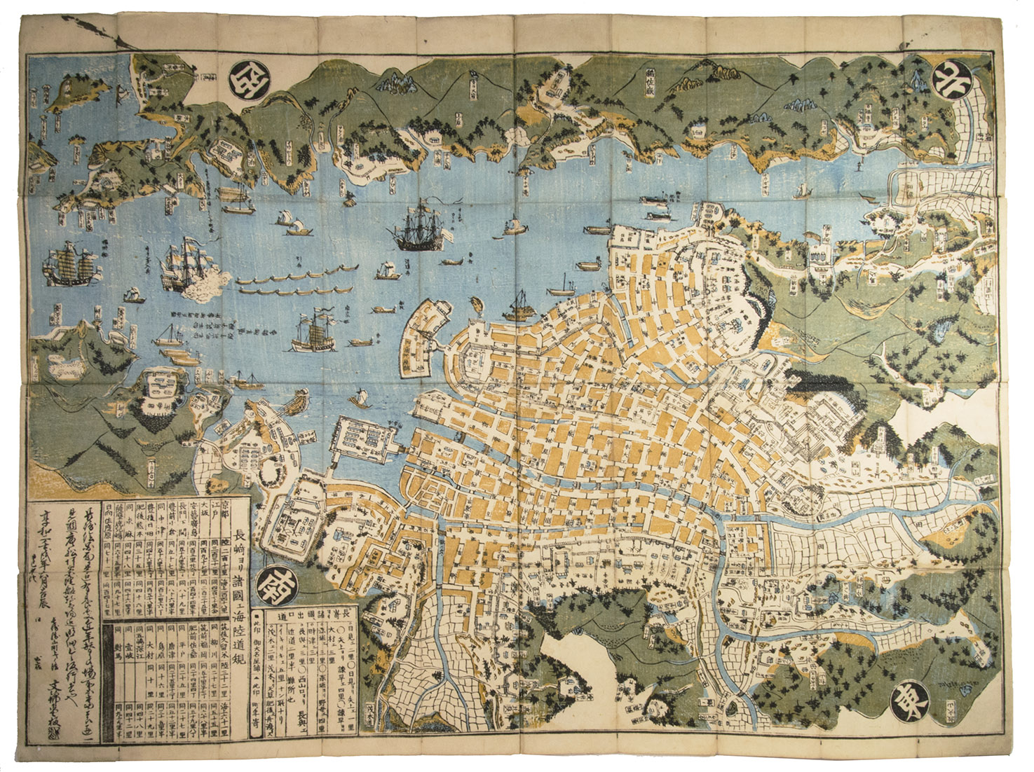 [MAP]. BUNKINDO HAN. - Hishu Nagasaki (no) zu [= plan of Nagasaki, Hizen province].[Nagasaki, Bunkindo, 1821]. 61.5 x 87 cm. Large folding woodcut map of the port and city of Nagasaki, printed in three colours (ochre, blue and green) on four sheets.  In Japanese ochre paper etui decorated with blue and white flowers and title label with Japanese characters pasted on, preserved in later dark blue cloth slipcase in Japanese style closing with two ivory clasps.