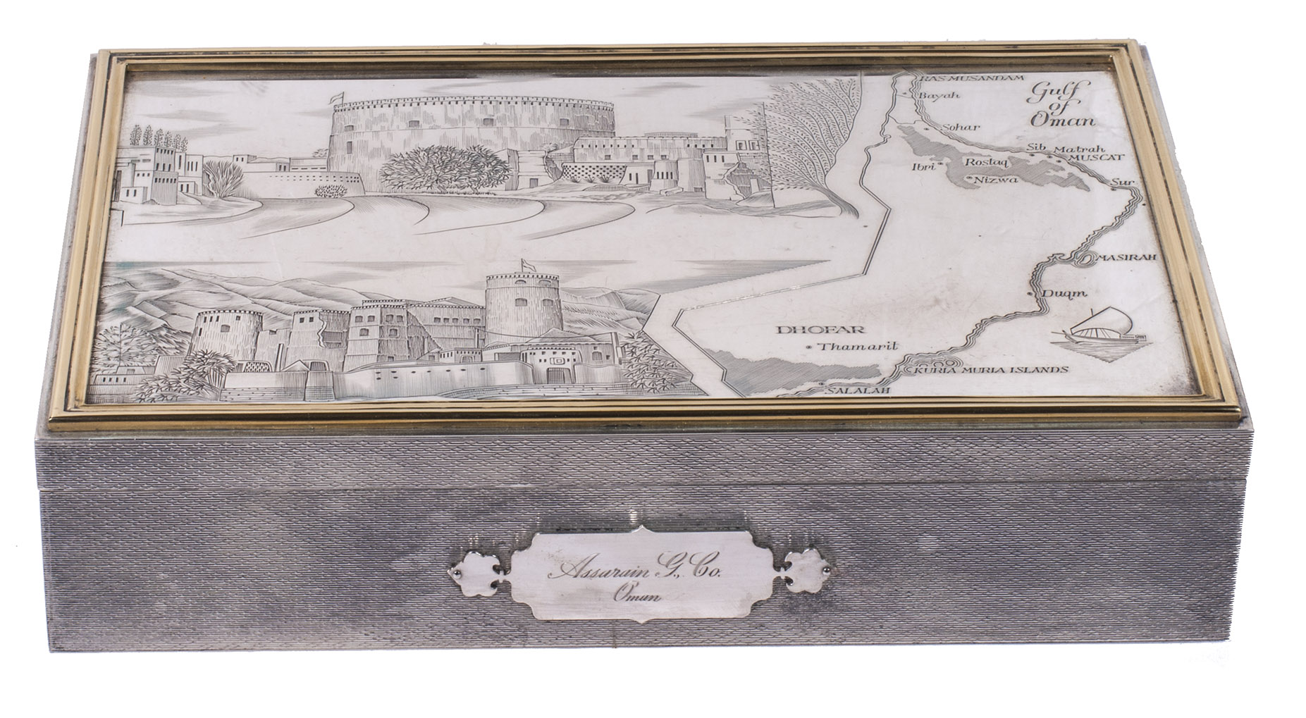 MACDONALD, George Grant (silversmith). - [Engraved silver cigar box commissioned by the Assarain Group of Companies].London, Assarain Group of Companies, Oman, 1990. With the map of Oman and 2 views engraved on the polished top. The cigar box (15 x 23 x 5 cm) is made of sterling (925) silver, with an engraved map and illustrations of Oman on the polished top, surrounded by a gilded frame, decorative engraving on the sides, a lined hardwood (mahogany?) inside, hallmarks on the underside. The cigar box is in a protective gold-tooled green morocco box (20 x 27 x 8 cm) with gold clasps, lined with green velvet and a white silk-like fabric.