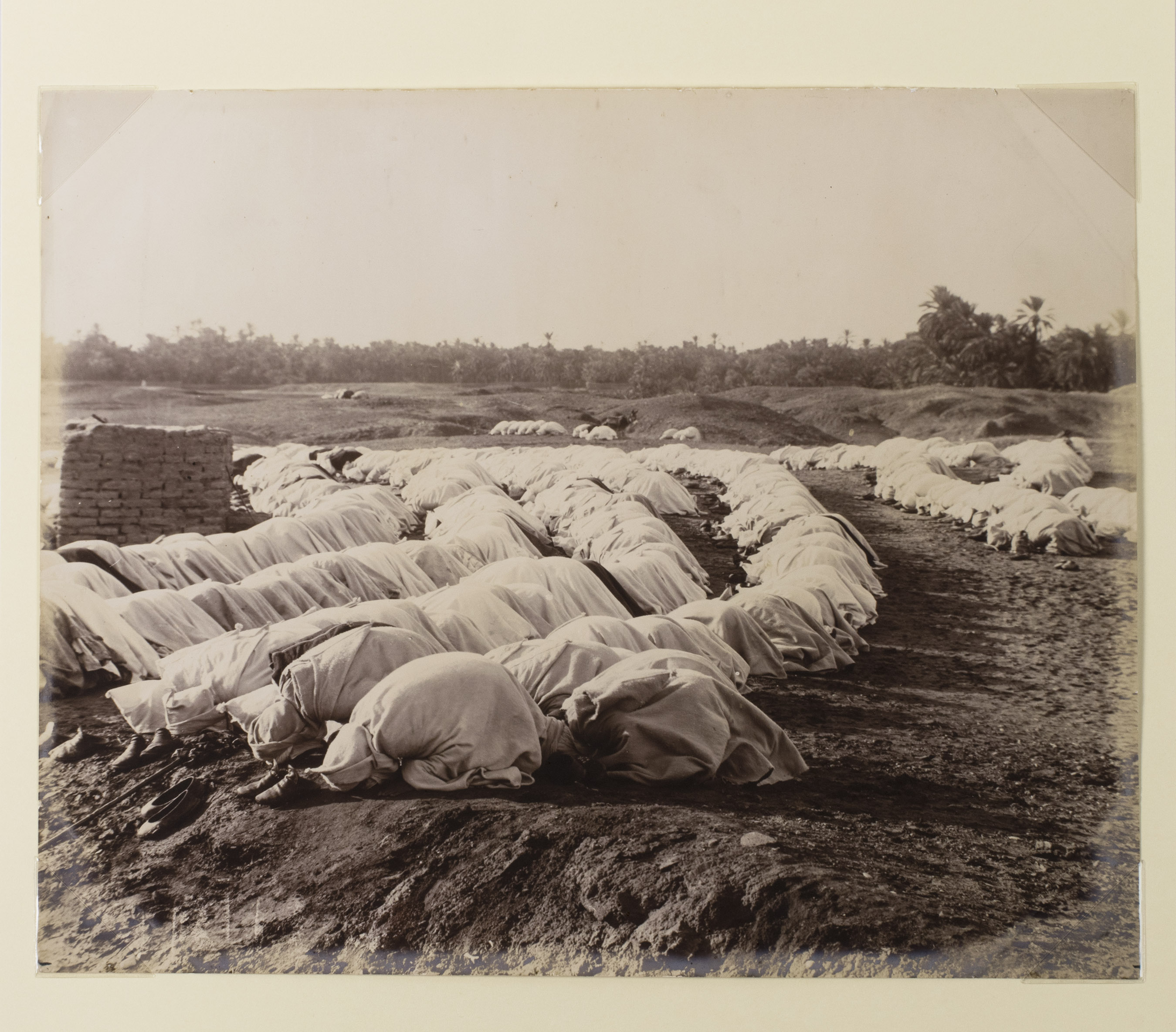 [PHOTOGRAPHY - MIDDLE EAST]. - [Arabic men praying outside].[Ca. 1880]. One albumen print (ca. 22.5 x 27.5 cm). Tipped onto a stiff paper mount (ca. 40 x 30 cm). Housed in a clear plastic sleeve.