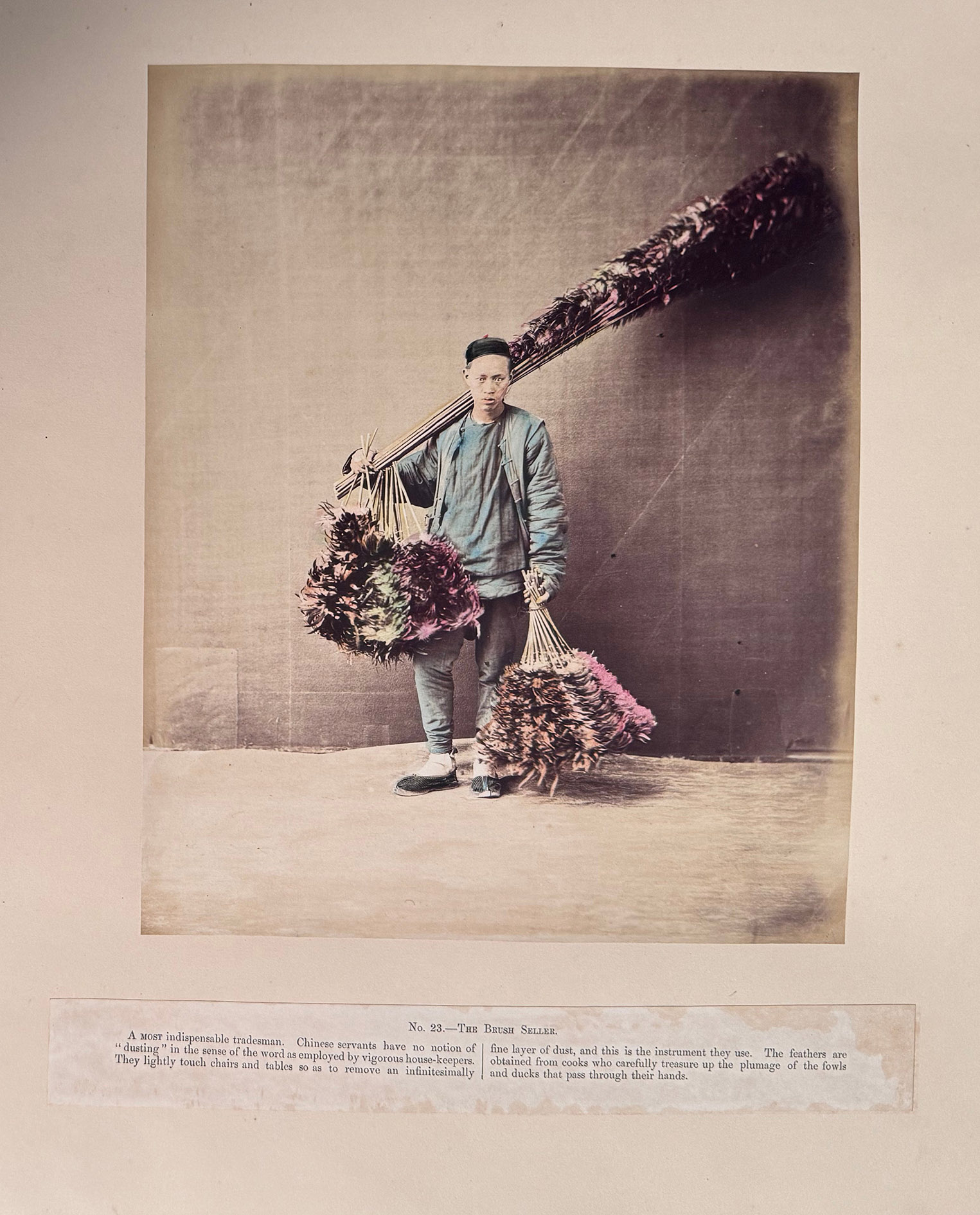 SAUNDERS, William Thomas (photographer). - [Portfolio of sketches of Chinese life and character].[Shanghai, China, 1871]. Oblong album (ca. 41 x 56 cm). With 51 hand-coloured photographs mounted on the recto of 50 leaves. Contemporary gold- and black-tooled red sheepskin, with a hand-carved wooden panel mounted into the front board, showing a Asian house with 4 people around a round table, a cat or similar pet in the foreground next to a person smoking a pipe (an opium pipe?) being approached by a servant with two plates food, gold-tooled turn-ins, gilt edges, white watered silk endpapers.