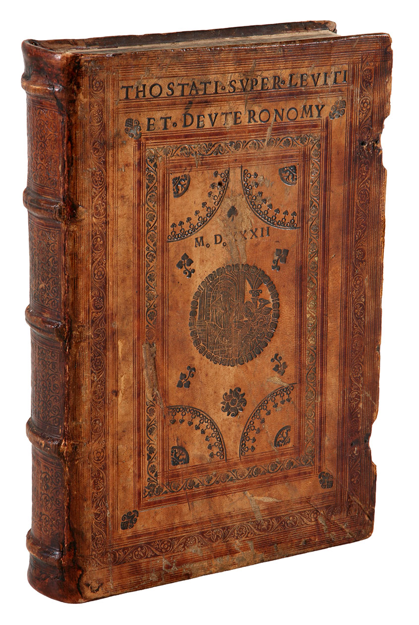 TOSTATUS (TOSTADO DE MADRIGAL), Alfonso. - Super Leviticum in sensu litterali nova et hactenus abscondita a se edita commentaria. (Colophon: Venice, Petrus Liechtenstein, 1529). With title-page printed in red and black with a large woodcut containing the coats of arms of the Emperor Charles V (Charles I of Spain) and two bishops (the author and perhaps a relative), leaf 2 with a woodcut of the author writing at his desk, with his arms, and a woodcut initial with the other bishop's arms inside the letter, the arms in the initial and some lines of text printed in red. Printed in two columns. With: (2) TOSTATUS, Alfonso. Opus super Deuteronomium.(Colophon: Venice, Petrus Liechtenstein, 1528). With title-page printed in red and black, leaf 1 with a woodcut of the author writing at his desk, with his arms (not the same woodcut as in ad 1), and a woodcut initial with the other bishop's arms as in ad 1. Printed in two columns. 2 works in 1 volume. Folio. Contemporary blind- and gold-tooled tanned sheepskin over wooden boards; each board in a panel design with 2 (on the back board 3) different vine rolls, rules, and on the front board a central medaillon depicting Bathsheba kneeling before King David playing his harp, and a half dozen separate stamps, with author and title at the head,