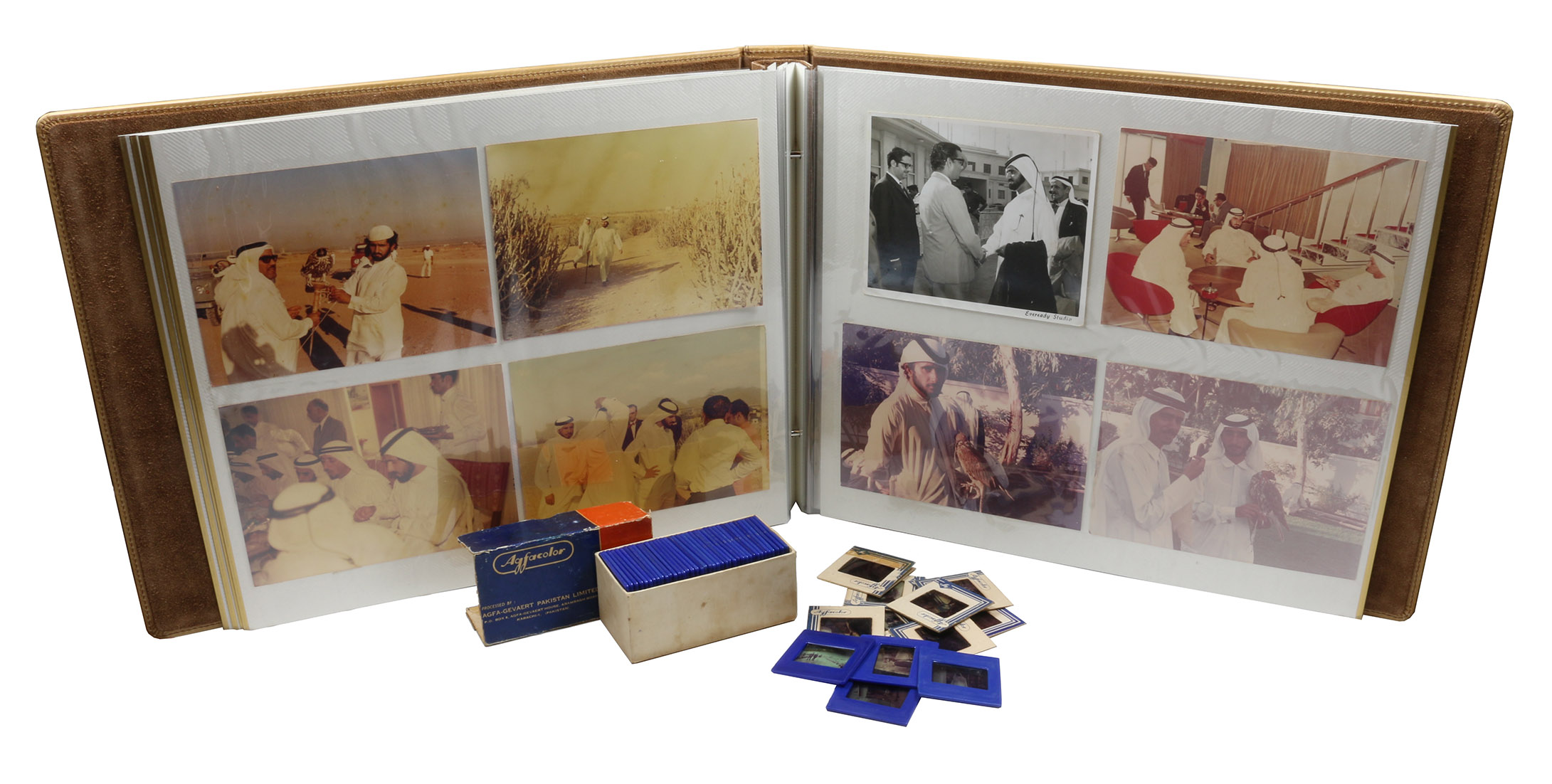 [DUBAI  ROYAL FAMILY]. - Photograph album.Pakistan, Early 1970s. 40 photographs (29 in colour and 11 black-and-white). Various sizes (300 x 207 mm to 125 x 125 mm). Includes 51 original colour slides. Stored in large, six-leaf self-adhesive tan leather album (oblong folio, 43 x 34 cm).